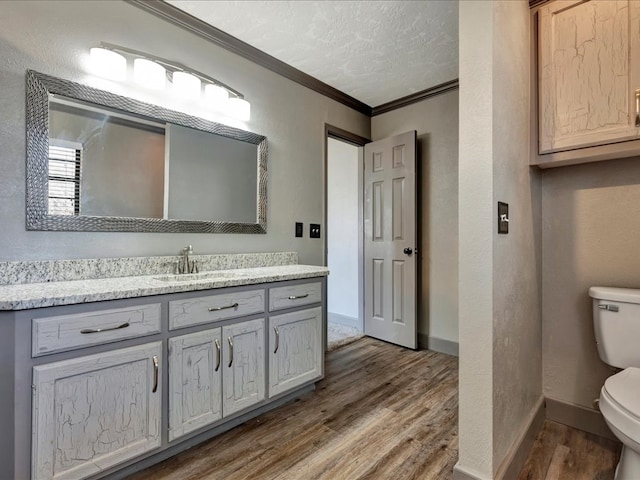 bathroom featuring crown molding, a textured ceiling, toilet, and wood finished floors