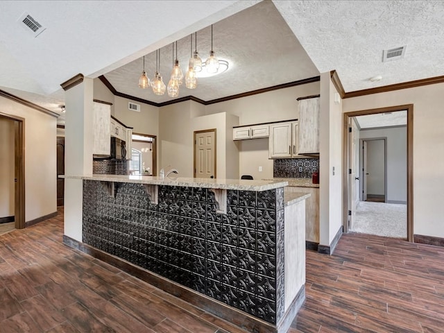 kitchen with a textured ceiling, dark wood-type flooring, backsplash, and visible vents