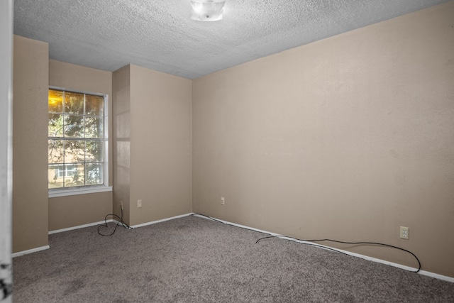 carpeted spare room with a textured ceiling