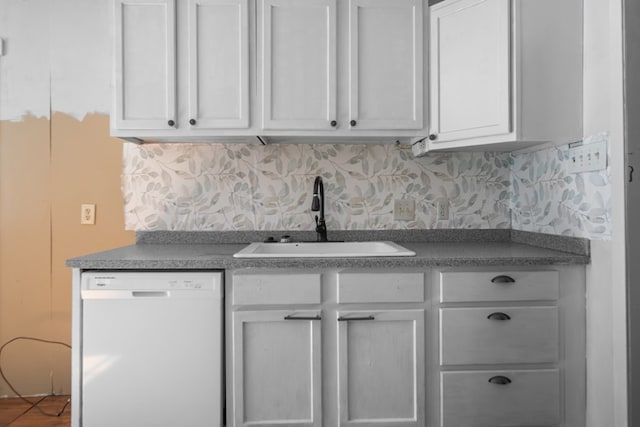 kitchen with white dishwasher, white cabinets, backsplash, and sink