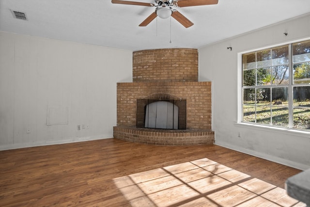 unfurnished living room with ceiling fan, a fireplace, and wood-type flooring