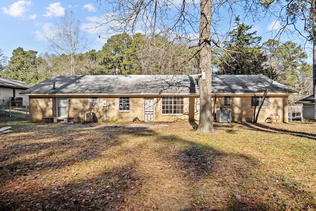 rear view of house with a lawn and central AC