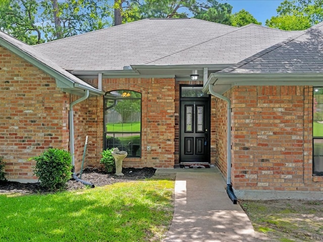 602 April Dr, Lufkin, TX 75904 - view of exterior entry featuring brick siding and roof with shingles