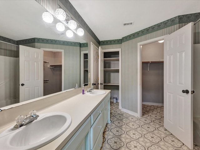 602 April Dr, Lufkin, TX 75904 - full bath featuring wallpapered walls, a walk in closet, double vanity, and tile patterned floors