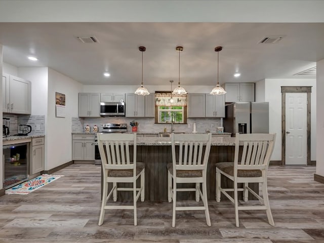 516 Westchester St, Diboll, TX 75941 - kitchen with appliances with stainless steel finishes, gray cabinets, light wood-type flooring, decorative backsplash, and recessed lighting