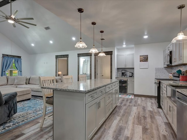 516 Westchester St, Diboll, TX 75941 - kitchen with open floor plan, appliances with stainless steel finishes, a kitchen breakfast bar, ceiling fan, and decorative backsplash