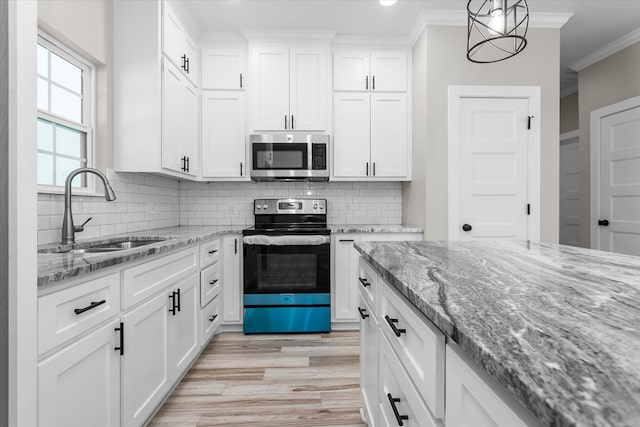 kitchen with stainless steel appliances, crown molding, sink, pendant lighting, and white cabinetry