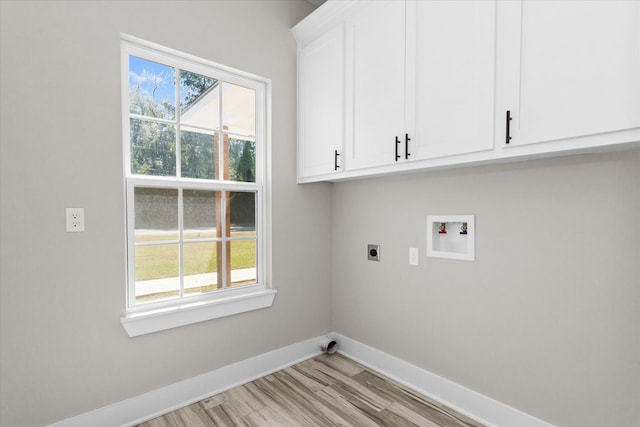 clothes washing area with electric dryer hookup, hookup for a washing machine, cabinets, and light hardwood / wood-style floors