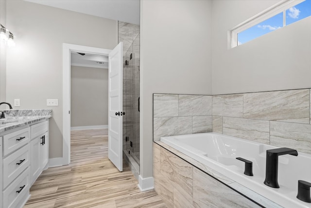 bathroom featuring separate shower and tub, hardwood / wood-style floors, and vanity