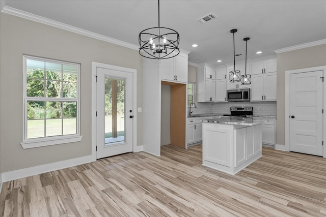 kitchen featuring white cabinets, appliances with stainless steel finishes, and pendant lighting