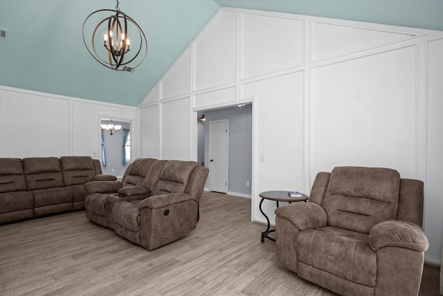 1504 Azalea Dr, Lufkin, TX 75904 - living area featuring a chandelier, a decorative wall, light wood finished floors, and high vaulted ceiling
