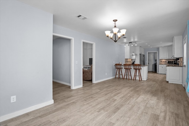 1504 Azalea Dr, Lufkin, TX 75904 - living area with a chandelier, light wood finished floors, and baseboards