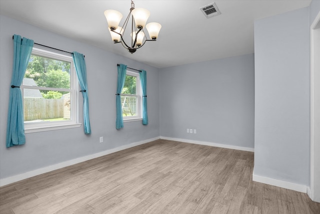 1504 Azalea Dr, Lufkin, TX 75904 - spare room with a chandelier, light wood-style floors, and baseboards