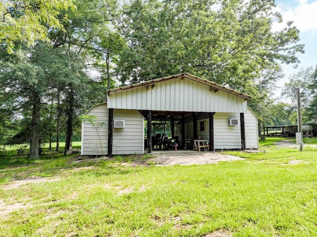 view of outbuilding featuring a lawn and a wall unit AC