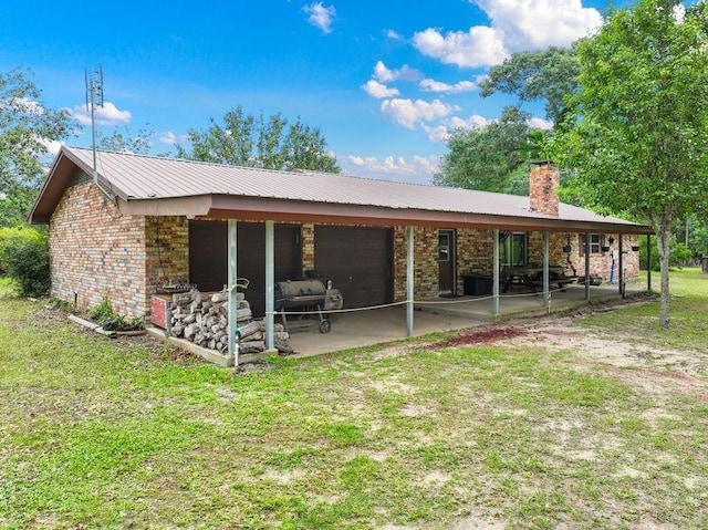 rear view of property with a lawn and a patio area