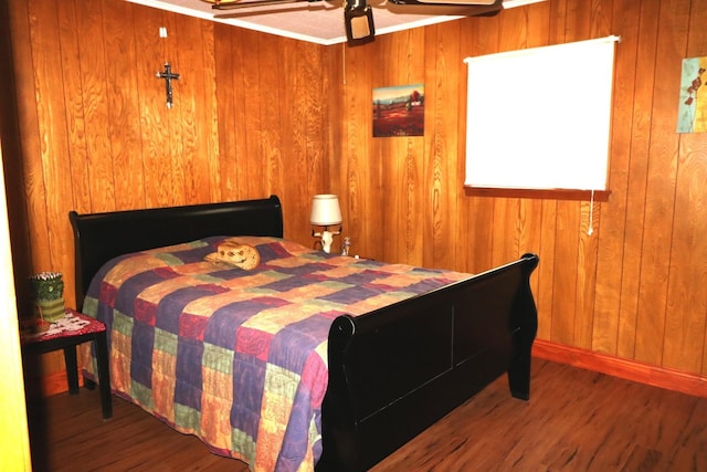 bedroom with wooden walls and hardwood / wood-style flooring