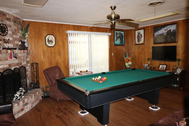 recreation room with a brick fireplace, wood walls, dark hardwood / wood-style floors, and billiards