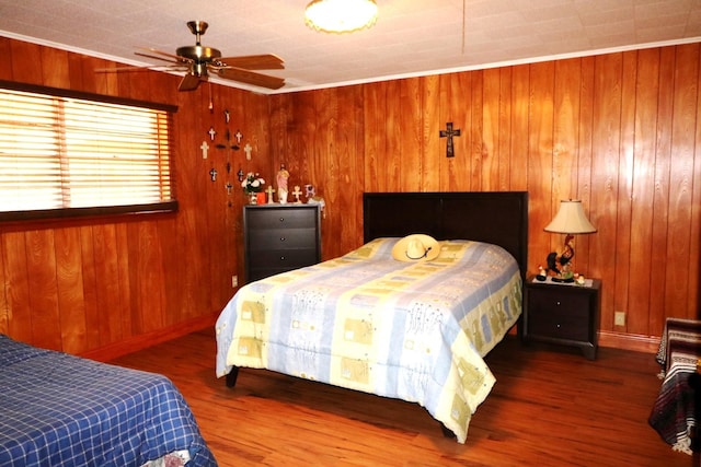 bedroom with hardwood / wood-style flooring, ceiling fan, crown molding, and wood walls