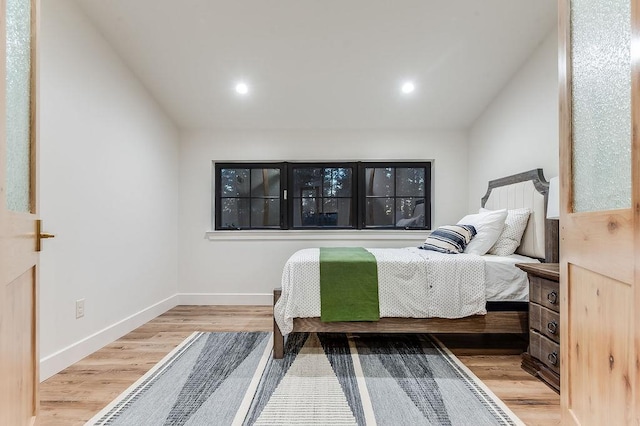 bedroom with recessed lighting, baseboards, lofted ceiling, and wood finished floors