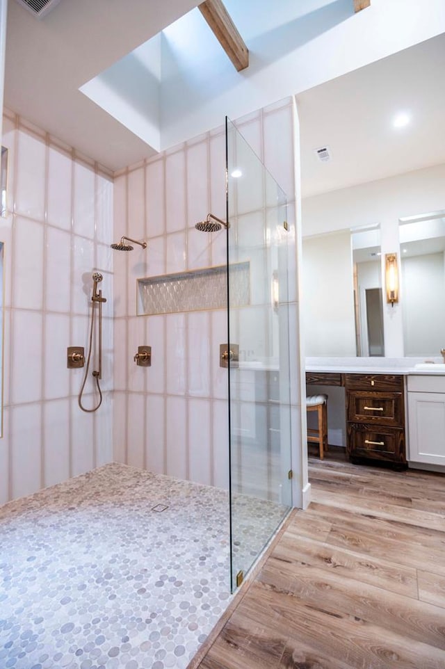 full bath with walk in shower, wood finished floors, and vanity