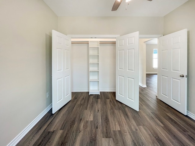 unfurnished bedroom featuring a ceiling fan, baseboards, dark wood-style flooring, and a closet