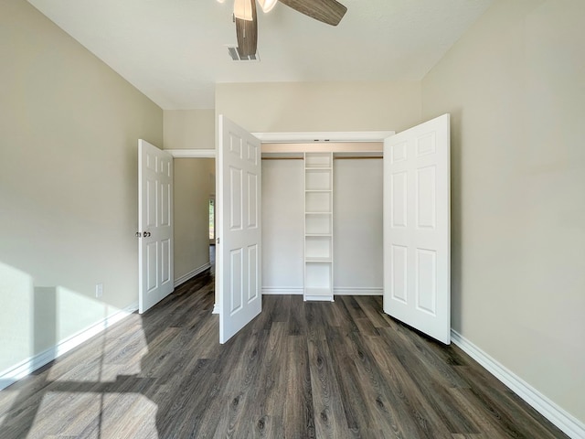unfurnished bedroom with a closet, visible vents, baseboards, and dark wood-style flooring