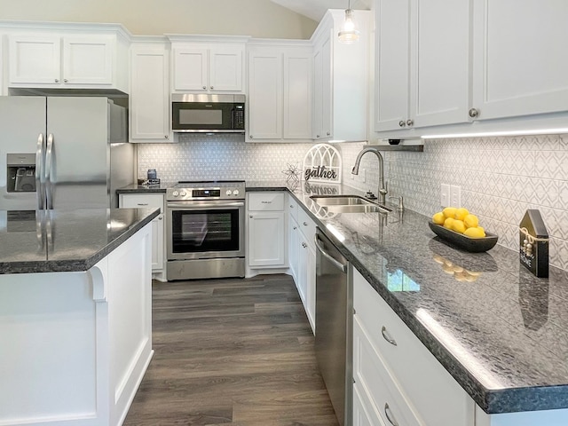 kitchen featuring white cabinets, a sink, decorative backsplash, dark wood-type flooring, and appliances with stainless steel finishes