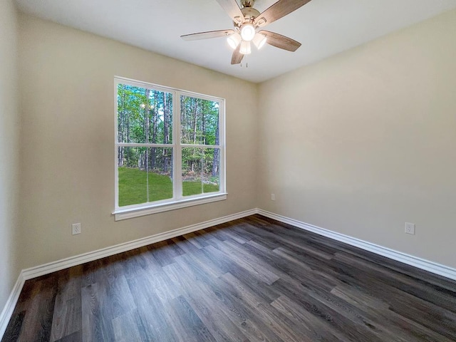 unfurnished room with baseboards, a ceiling fan, and dark wood-style floors