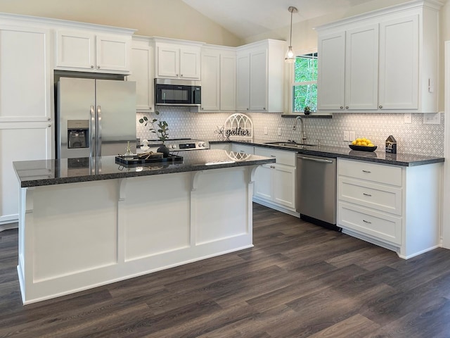kitchen with white cabinets, a sink, lofted ceiling, dark wood-type flooring, and appliances with stainless steel finishes