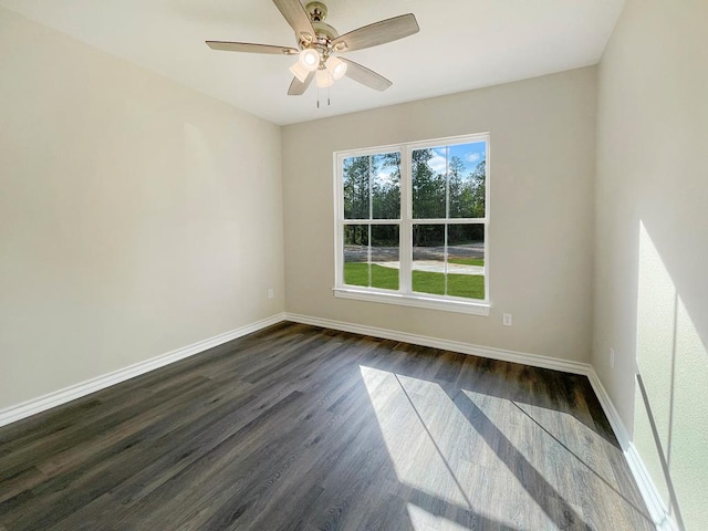 spare room with a ceiling fan, baseboards, and dark wood-style flooring