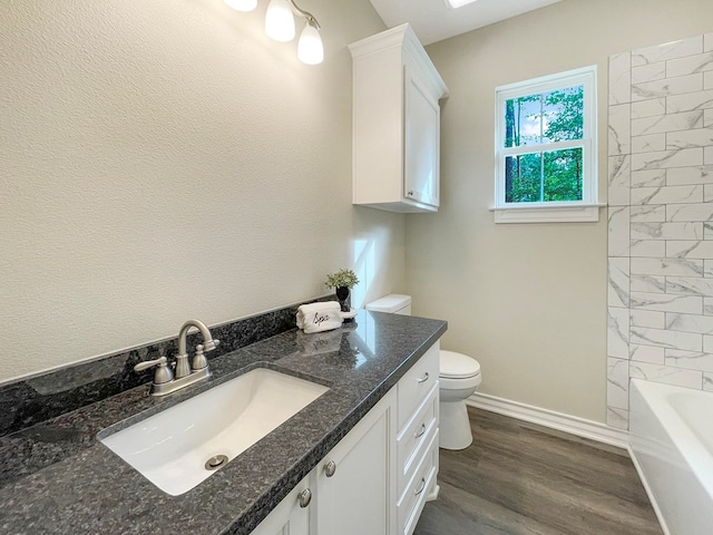 bathroom with baseboards, toilet, vanity, and wood finished floors