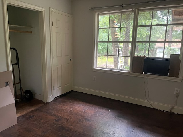 414 Ridge Crest St, Lufkin, TX 75901 - unfurnished bedroom with dark wood-type flooring, multiple windows, and baseboards