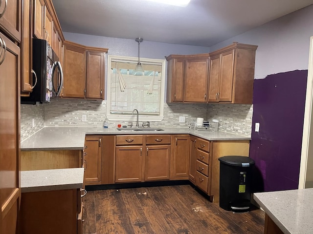 414 Ridge Crest St, Lufkin, TX 75901 - kitchen with a sink, dark wood-style flooring, tasteful backsplash, brown cabinetry, and black microwave