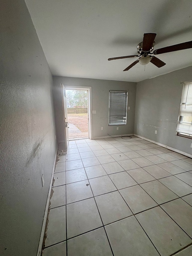 tiled empty room featuring ceiling fan