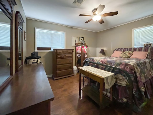 bedroom with ceiling fan, crown molding, and dark wood-type flooring