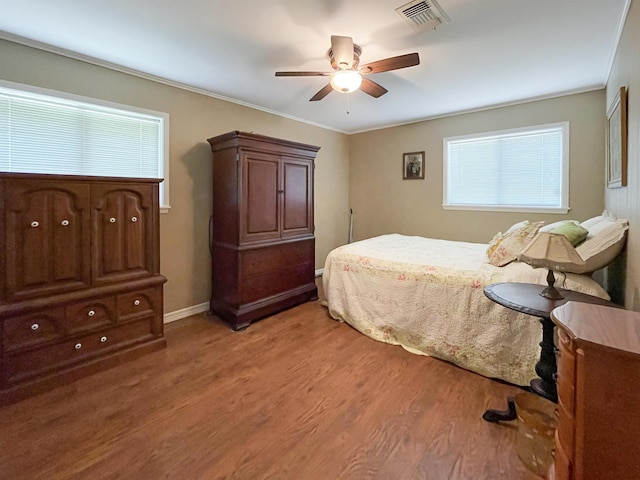 bedroom featuring ceiling fan, wood-type flooring, and ornamental molding