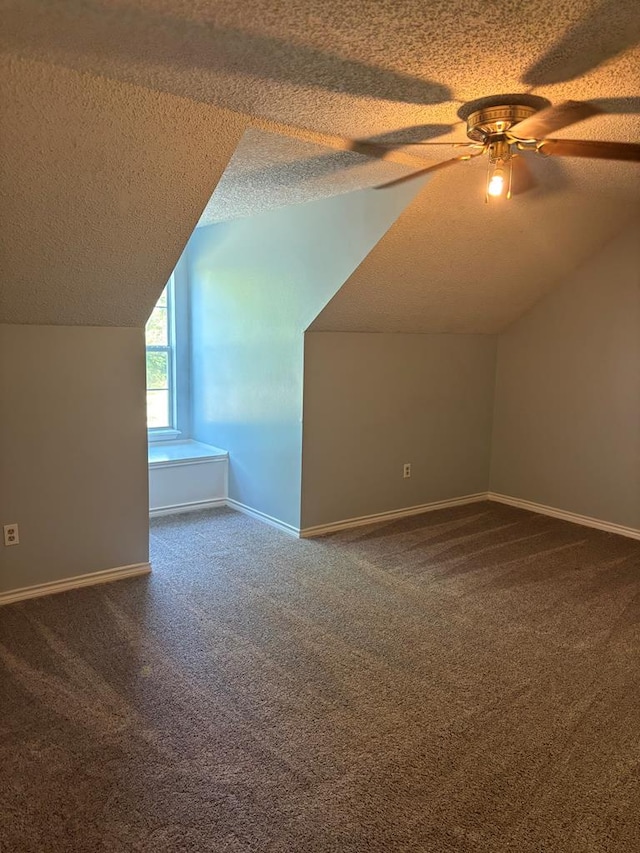 additional living space featuring baseboards, a textured ceiling, and carpet flooring