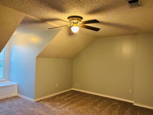 bonus room featuring a textured ceiling, carpet flooring, visible vents, and a ceiling fan