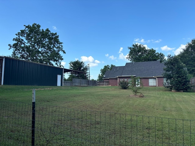 view of yard with an outbuilding, fence, and an outdoor structure