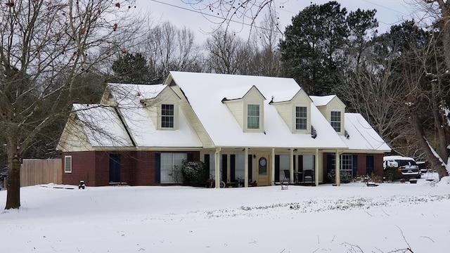 view of front of home with brick siding and fence