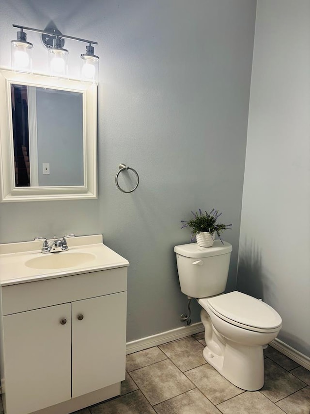 bathroom featuring baseboards, vanity, toilet, and tile patterned floors