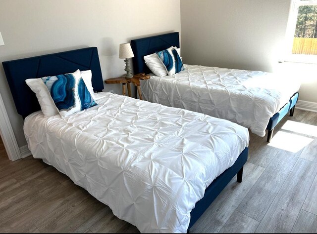 bedroom featuring baseboards and wood finished floors