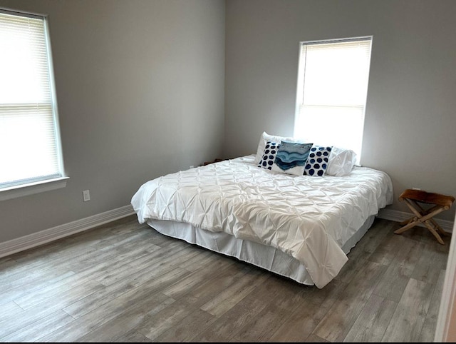 bedroom with baseboards and wood finished floors