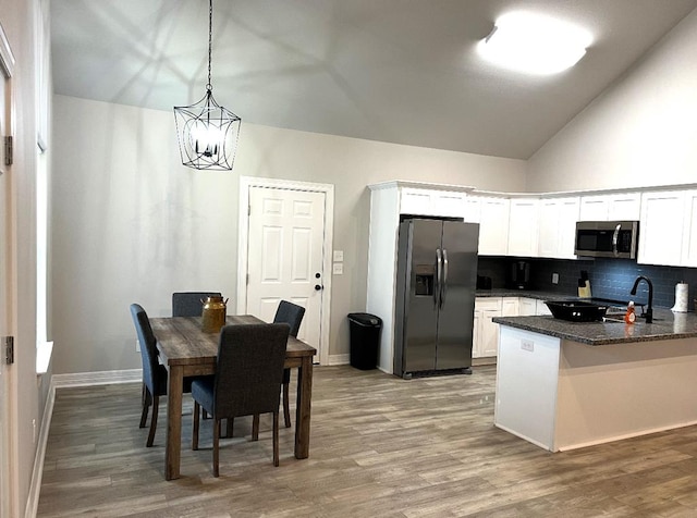 kitchen with white cabinetry, light wood-style flooring, tasteful backsplash, and stainless steel appliances