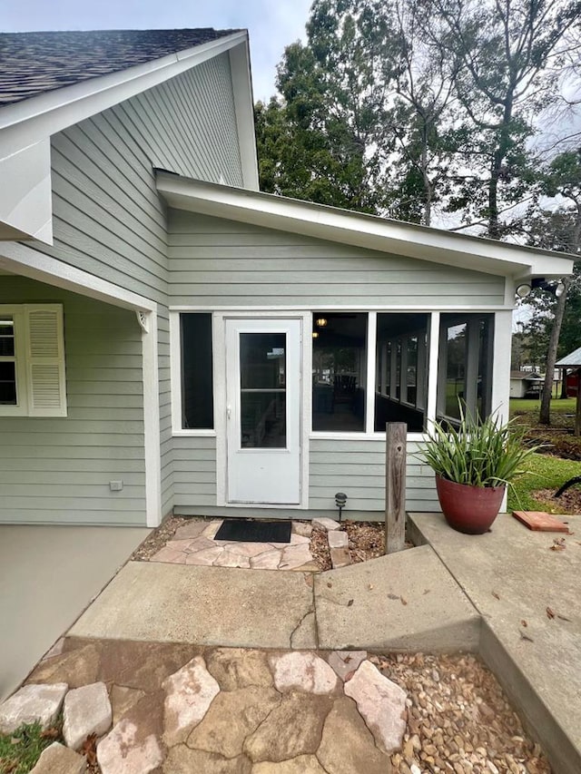 view of exterior entry with a patio