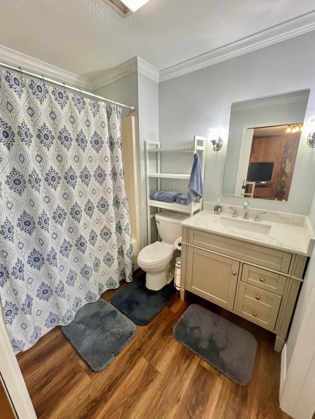 full bathroom featuring vanity, a textured ceiling, crown molding, wood-type flooring, and toilet