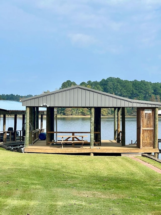 view of dock with a yard and a water view