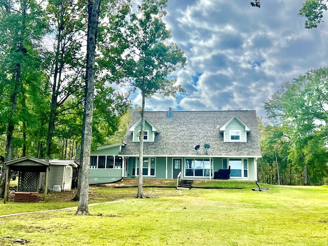 new england style home with a front yard and a storage unit