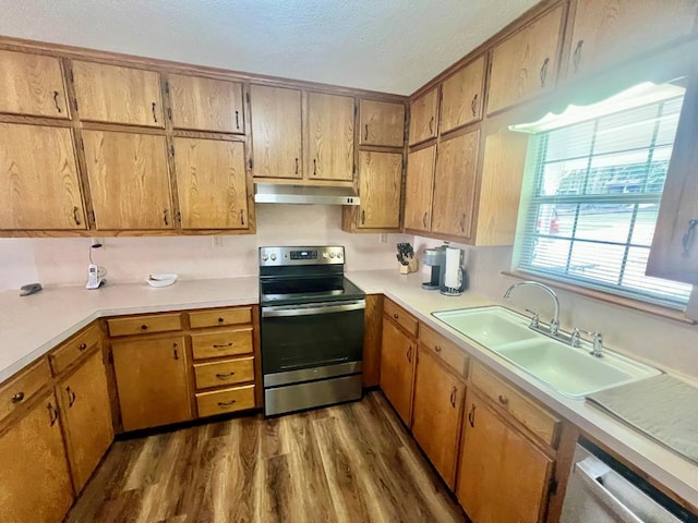 419 Pinemont Dr, Hemphill, TX 75948 - kitchen featuring appliances with stainless steel finishes, a sink, under cabinet range hood, dark wood-type flooring, and light countertops