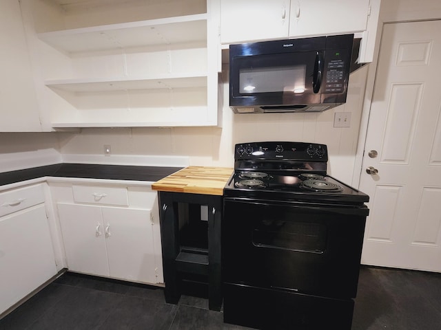 kitchen with white cabinetry, dark tile patterned floors, and black appliances